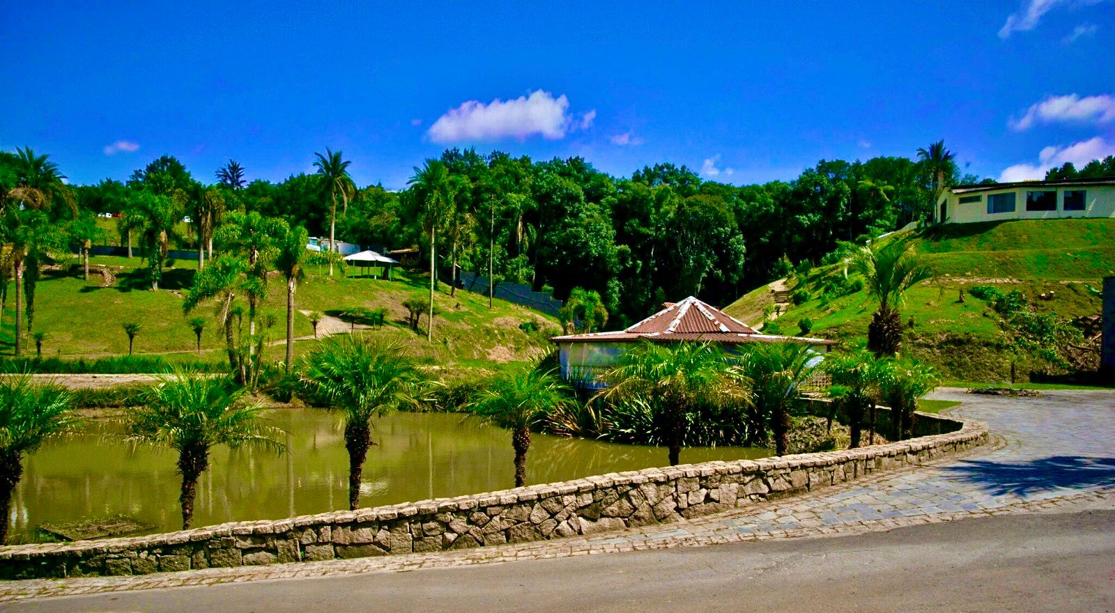 Lago e jardins da Chácara O Alvo com muro de pedra natural